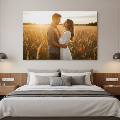 Couple embracing in a field with a sunset, displayed as a custom canvas wall art above a bed.
