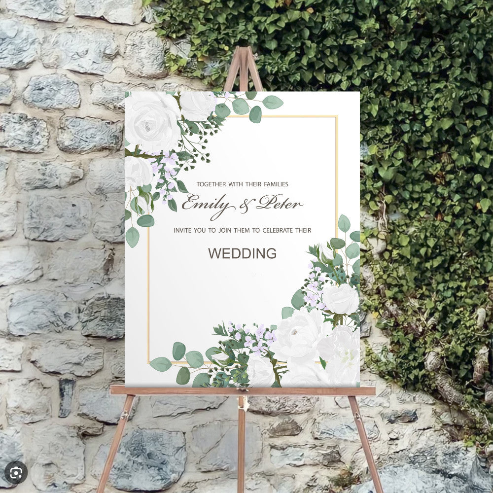 Custom wedding welcome sign printed on foam board, featuring floral design and personalized names, displayed on easel against stone wall.
