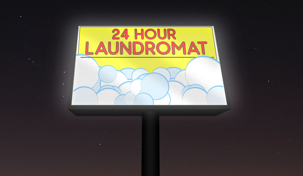 Backlit vinyl banner for 24 hour laundromat, illuminated sign with bubbles graphic, displayed at night for high visibility.