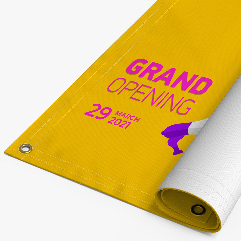 Custom yellow vinyl banner with grommets, grand opening design and rolled corner, example of personalized banner printing.